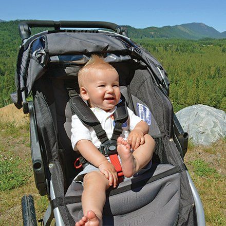 Smiling baby boy in stroller with mountains SZ100