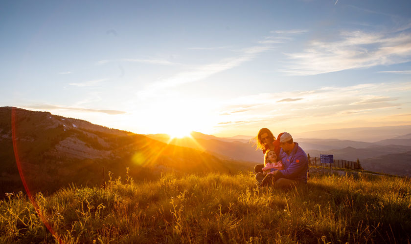 A family enjoys the summer sunset from atop Snowmass mountain