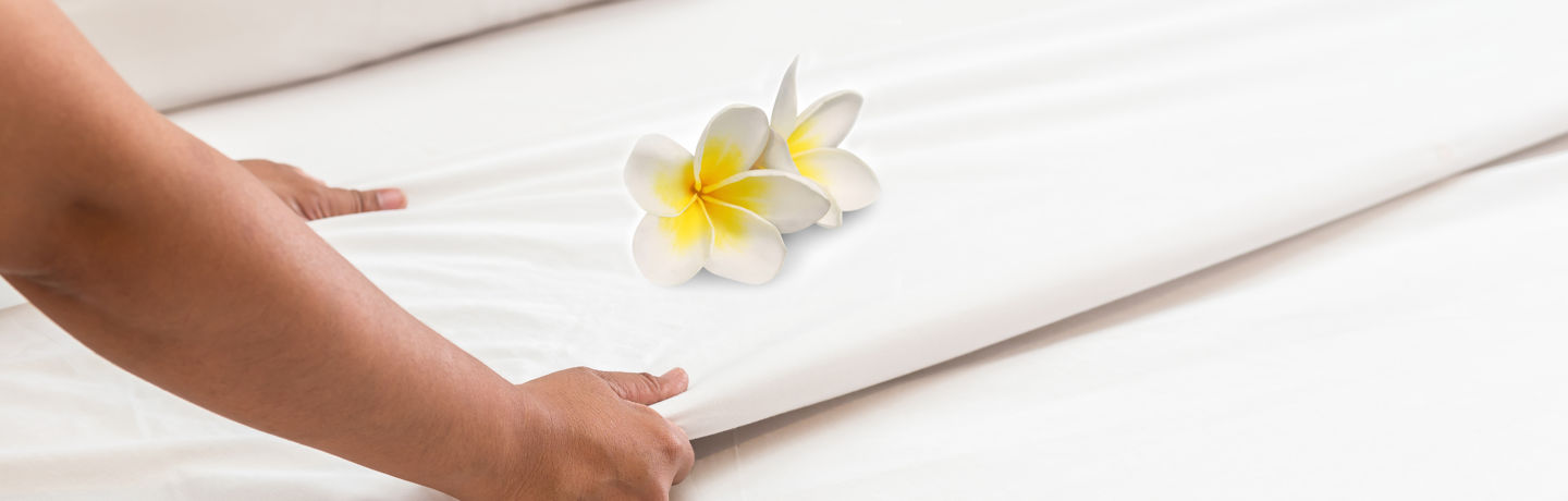 Housekeeper Making Bed with Flower Detail