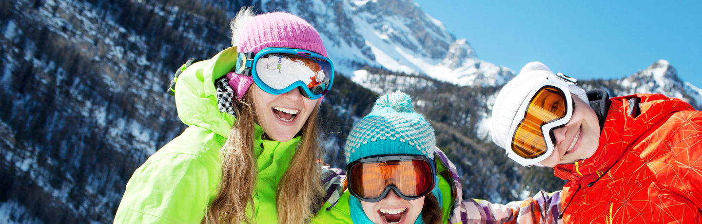 Three Kids Smiling In Ski Gear