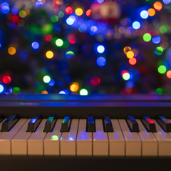 Piano keyboard and Christmas pine tree illuminations. Vibrant colors, Holidays concept