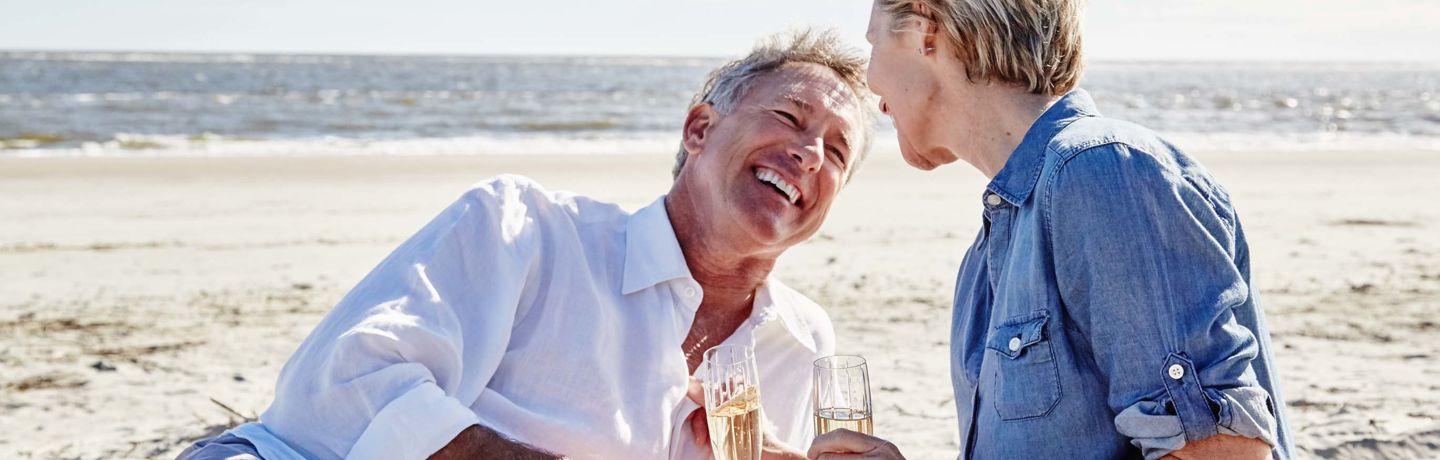 Couple drinking champagne on beach
