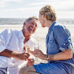 Couple drinking champagne on beach
