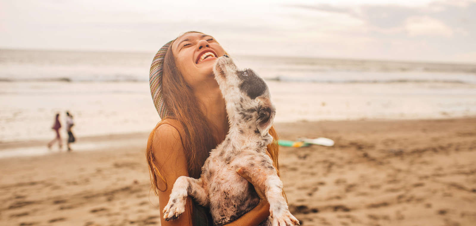 Girl Holding Dog on Beach